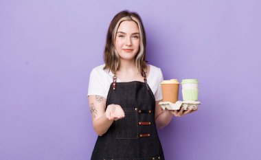 Güzel, beyaz bir kadın mutlu bir şekilde gülümsüyor ve bir konsept sunuyor. kahve konseptini kaldır.