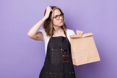 Kafası karışmış, kafası karışmış, kaşınan beyaz bir kadın. teslimat ve paket konsepti