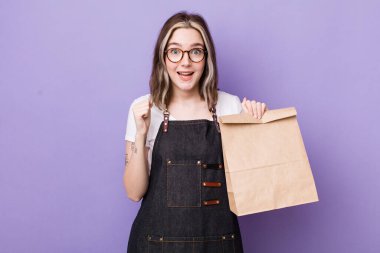 Kafkasyalı bir kadın şoke olmuş, gülüyor ve başarıyı kutluyor. teslimat ve paket konsepti