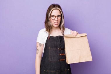 Kafkasyalı bir kadın iğreniyor, sinirleniyor ve dili dışarı çıkıyor. teslimat ve paket konsepti