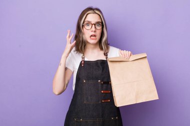 Güzel, beyaz bir kadın ellerini havaya kaldırarak çığlık atıyor. teslimat ve paket konsepti