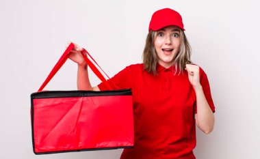 Kafkasyalı bir kadın şoke olmuş, gülüyor ve başarıyı kutluyor. Pizza teslimatı kavramı