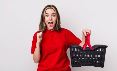 Kafkasyalı bir kadın şoke olmuş, gülüyor ve başarıyı kutluyor. boş alışveriş sepeti kavramı