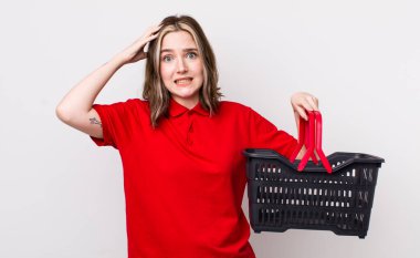 Kafkasyalı bir kadın stresli, endişeli ya da korkmuş, elleri başının üstünde. boş alışveriş sepeti kavramı