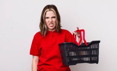 Kafkasyalı bir kadın iğreniyor, sinirleniyor ve dili dışarı çıkıyor. boş alışveriş sepeti kavramı