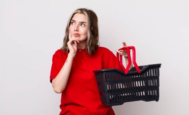 Kafkasyalı bir kadın düşünüyor, kuşkulu ve şaşkın hissediyor. boş alışveriş sepeti kavramı