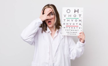 Güzel, beyaz bir kadın şok olmuş, korkmuş ya da korkmuş görünüyor. Yüzü elle kapatılmış. optik konsept