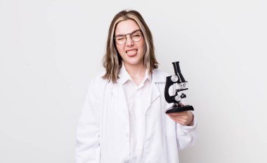 Neşeli ve asi tavırları olan, şaka yapan ve dilini dışarı çıkaran oldukça beyaz bir kadın. Mikroskop konseptine sahip bilim adamı