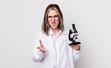 Kafkasyalı bir kadın sinirli, sinirli ve sinirli görünüyor. Mikroskop konseptine sahip bilim adamı