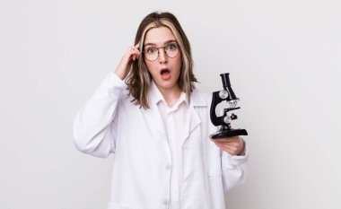 Kafkasyalı bir kadın şaşırmış görünüyor, yeni bir düşünce, fikir ya da konsept fark ediyor. Mikroskop konseptine sahip bilim adamı