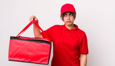 Güzel İspanyol bir kadın üzgün, üzgün ya da kızgın hissediyor ve yan tarafa bakıyor. Pizza dağıtımı kavramı