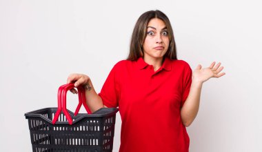 Oldukça İspanyol bir kadın şaşkın, şaşkın ve şüpheci hissediyor. boş alışveriş sepeti kavramı