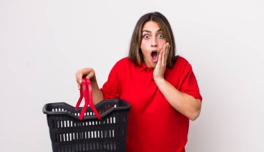 Oldukça İspanyol bir kadın şok olmuş ve korkmuş hissediyor. boş alışveriş sepeti kavramı