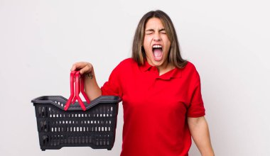 Oldukça İspanyol bir kadın agresif bir şekilde bağırıyor, çok kızgın görünüyor. boş alışveriş sepeti kavramı