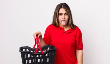 Güzel İspanyol kadın iğreniyor, sinirleniyor ve dili dışarı çıkıyor. boş alışveriş sepeti kavramı