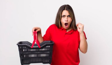 Kızgın bir ifadeyle saldırganca bağıran oldukça İspanyol bir kadın. boş alışveriş sepeti kavramı