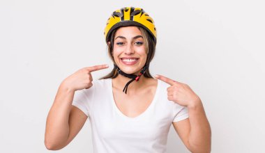 Güzel, İspanyol bir kadın, kendine güvenerek kendi gülüşünü işaret ediyor. bisiklet konsepti