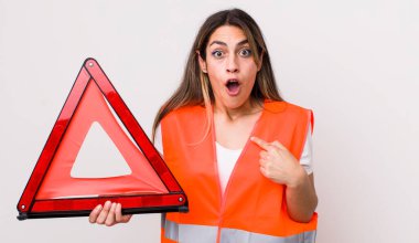 Şok olmuş ve ağzı açık, kendini işaret eden güzel İspanyol bir kadın. araba üçgeni kavramı