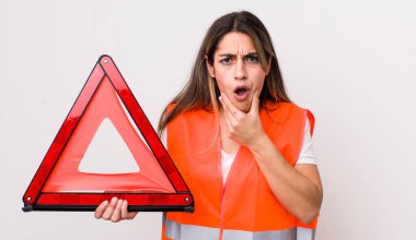 Ağzı ve gözleri sonuna kadar açık ve eli çenesinde olan güzel İspanyol bir kadın. araba üçgeni kavramı