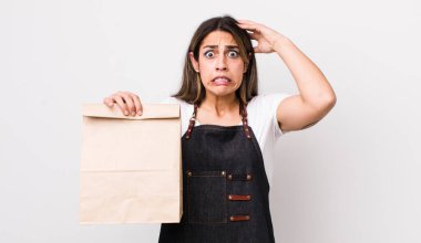 Oldukça İspanyol bir kadın stresli, endişeli ya da korkmuş, elleri başının üstünde. teslimat ve paket konsepti