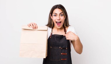 Güzel İspanyol bir kadın mutlu hissediyor ve heyecanla kendini işaret ediyor. teslimat ve paket konsepti