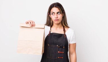 Güzel İspanyol bir kadın üzgün, üzgün ya da kızgın hissediyor ve yan tarafa bakıyor. teslimat ve paket konsepti