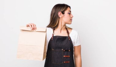 Profil görünümlü güzel İspanyol kadın hayal kuruyor, hayal kuruyor ya da hayal kuruyor. teslimat ve paket konsepti