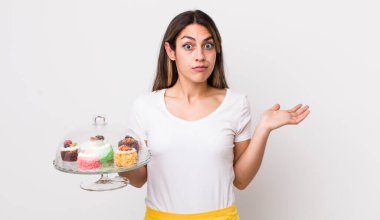 Oldukça İspanyol bir kadın şaşkın, şaşkın ve şüpheci hissediyor. Ev yapımı kek konsepti