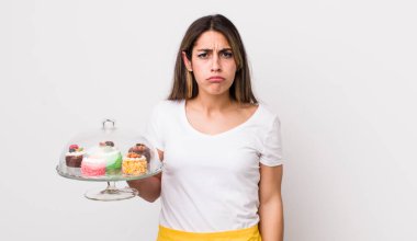 Güzel İspanyol bir kadın üzgün ve mızmızlanıyor. Mutsuz bir bakışı var ve ağlıyor. Ev yapımı kek konsepti