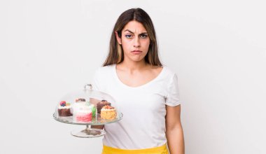 Kafası karışık ve kafası karışık bir İspanyol kadın. Ev yapımı kek konsepti