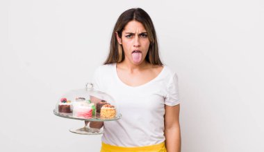 Güzel İspanyol kadın iğreniyor, sinirleniyor ve dili dışarı çıkıyor. Ev yapımı kek konsepti