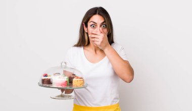 Güzel, İspanyol bir kadın elleri ile ağzını kapatıyor. Ev yapımı kek konsepti