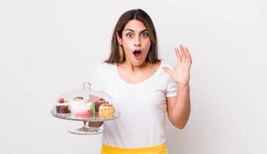 Güzel İspanyol kadın ellerini havaya kaldırarak çığlık atıyor. Ev yapımı kek konsepti