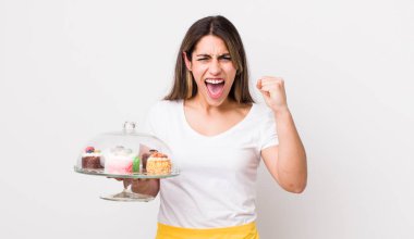 Kızgın bir ifadeyle saldırganca bağıran oldukça İspanyol bir kadın. Ev yapımı kek konsepti