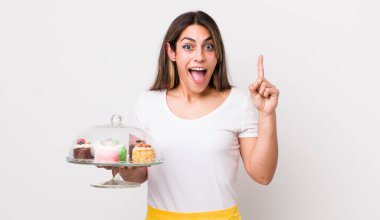 Güzel İspanyol bir kadın bir fikri fark ettikten sonra mutlu ve heyecanlı bir dahi gibi hissediyor. Ev yapımı kek konsepti