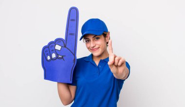 Güzel İspanyol kadın gülümsüyor ve arkadaş canlısı görünüyor, bir numarayı gösteriyor. Bir numaralı hayran eli.