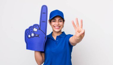 Güzel İspanyol kadın gülümsüyor ve arkadaş canlısı görünüyor, üç numarayı gösteriyor. Bir numaralı hayran eli.