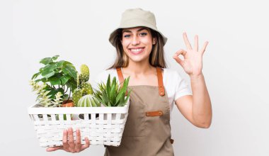 Güzel İspanyol bir kadın kendini mutlu hissediyor, iyi bir jestle onaylıyor. Bitkiler ve gargara konsepti