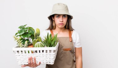 Güzel İspanyol bir kadın üzgün ve mızmızlanıyor. Mutsuz bir bakışı var ve ağlıyor. Bitkiler ve gargara konsepti