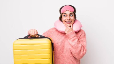 Güzel, İspanyol bir kadın mutlu ve kendinden emin bir ifadeyle gülümsüyor, elleri çenesinde. uçuş yolcu kavramı