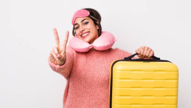 Güzel İspanyol kadın gülümsüyor ve arkadaş canlısı görünüyor, iki numarayı gösteriyor. uçuş yolcu kavramı