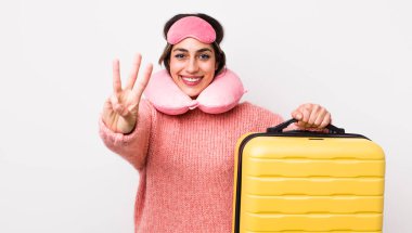 Güzel İspanyol kadın gülümsüyor ve arkadaş canlısı görünüyor, üç numarayı gösteriyor. uçuş yolcu kavramı