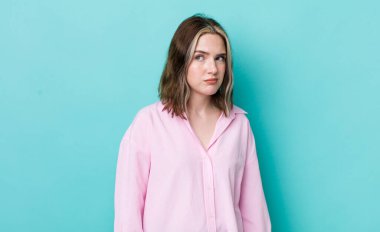 pretty caucasian woman feeling sad, upset or angry and looking to the side with a negative attitude, frowning in disagreement