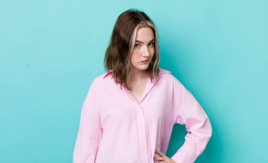 pretty caucasian woman looking proud, confident, cool, cheeky and arrogant, smiling, feeling successful