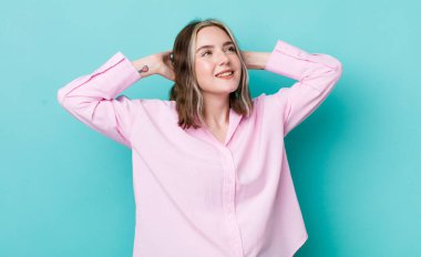 pretty caucasian woman smiling and feeling relaxed, satisfied and carefree, laughing positively and chilling