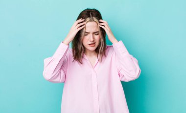 pretty caucasian woman looking stressed and frustrated, working under pressure with a headache and troubled with problems