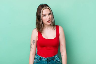 pretty caucasian woman feeling puzzled and confused, with a dumb, stunned expression looking at something unexpected