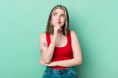 pretty caucasian woman thinking, feeling doubtful and confused, with different options, wondering which decision to make