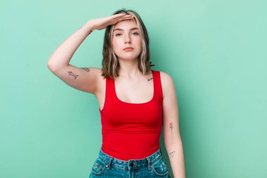 pretty caucasian woman greeting the camera with a military salute in an act of honor and patriotism, showing respect