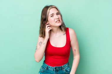 pretty caucasian woman feeling stressed, frustrated and tired, rubbing painful neck, with a worried, troubled look